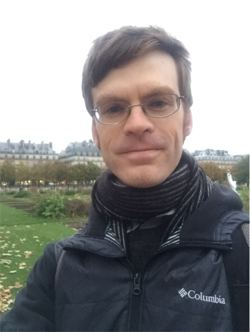 A headshot of Brooks Thomas with the Tuileries Garden in the background.